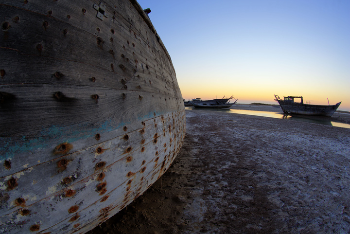 لنج‌های خسته از سال‌های سفر و رنج، اکنون زیر آفتاب سواحل خلیج‌فارس آرام گرفته‌اند